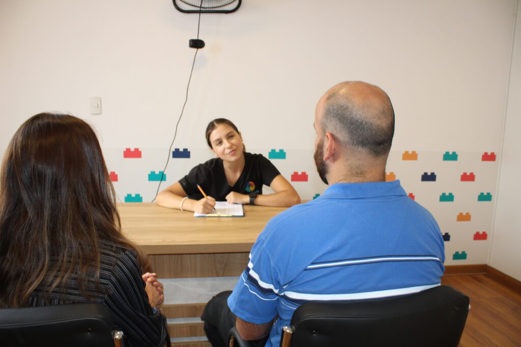 Psicóloga infantil conversando con padres durante una sesión de orientación en LegoMente.