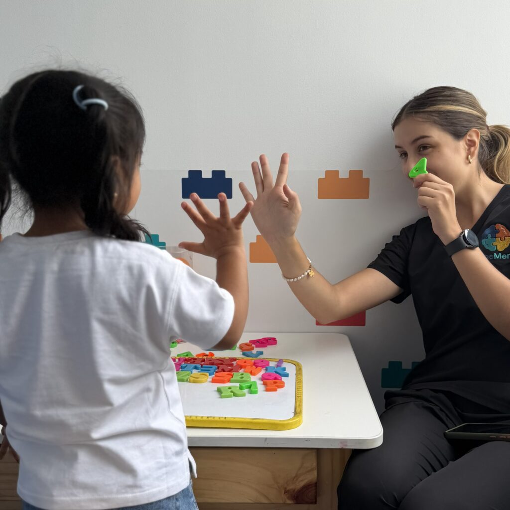 Terapeuta infantil jugando con una niña y piezas didácticas para trabajar comunicación y turnos en LegoMente.